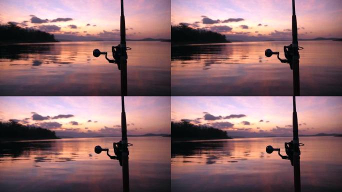 日落时钓鱼湖的视频，日落背景的剪影钓鱼竿