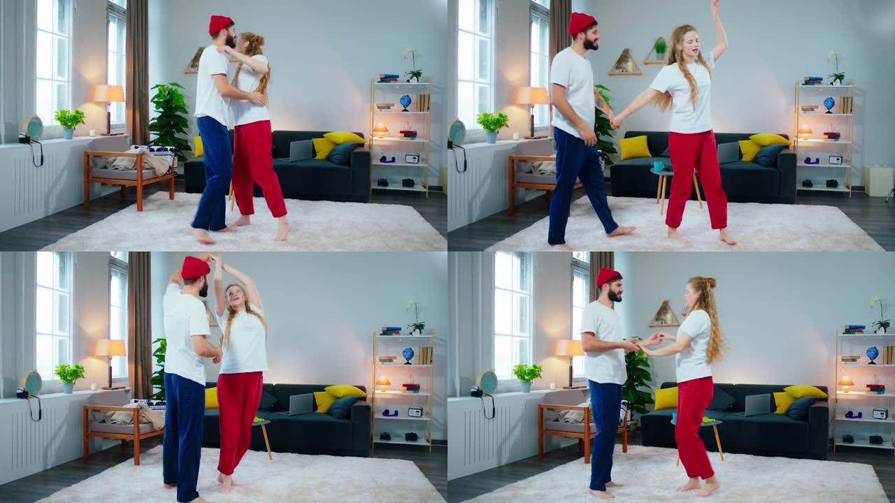 穿着睡衣在客厅的家中拥抱和跳舞浪漫的年轻夫妇，他们一起享受这一刻，笑脸