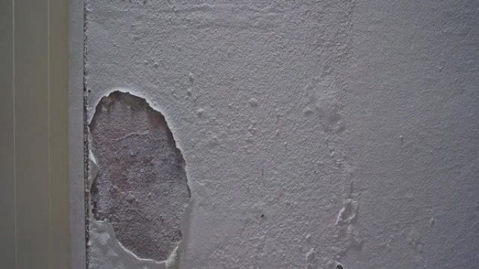 破裂的油漆屋墙的多莉滑块。破坏了墙上的白色油漆。旧风化墙老房子的垃圾质地。抽象白色和灰色水泥墙背景或