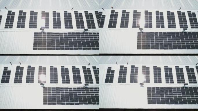 在工厂屋顶上安装太阳能电池板的工人团队