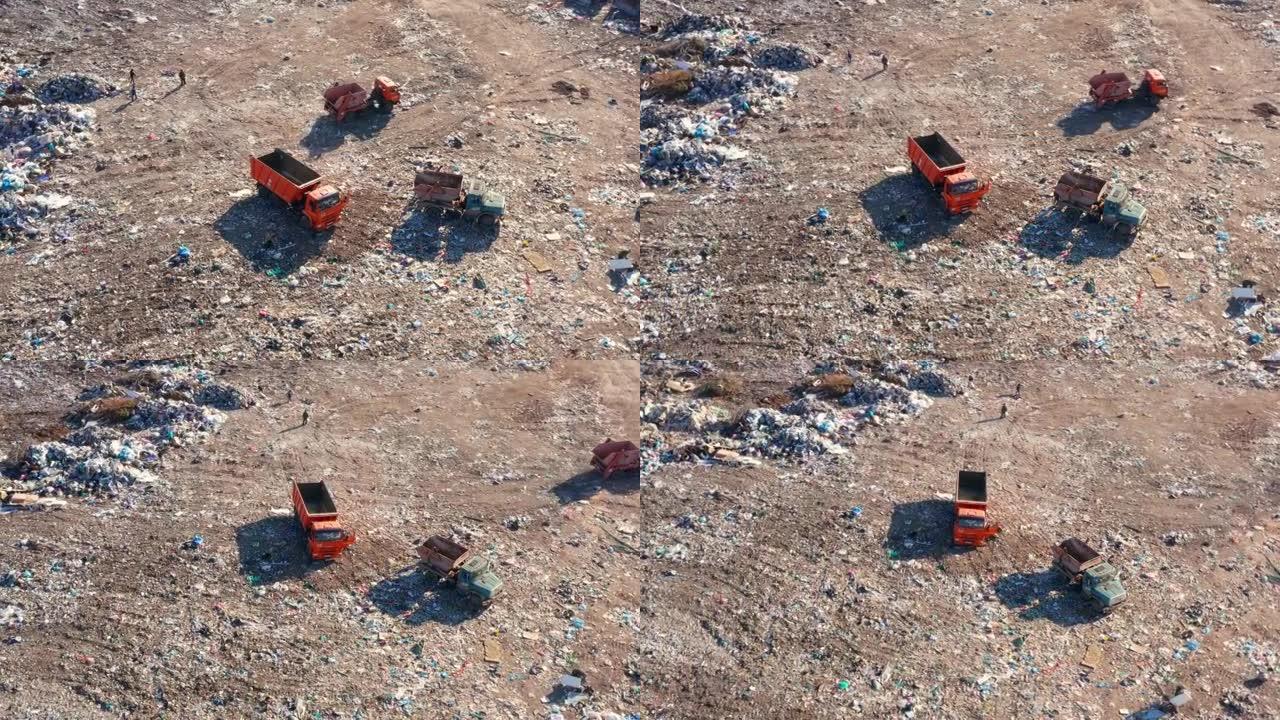 浪费人类生命。垃圾车倾倒垃圾污染产品，一群工人在垃圾填埋场分类垃圾。鸟瞰图。