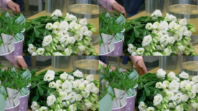 女花店收集一束年轻的白玫瑰。玫瑰花蕾在结束前开花不同。在温室里工作。小型企业