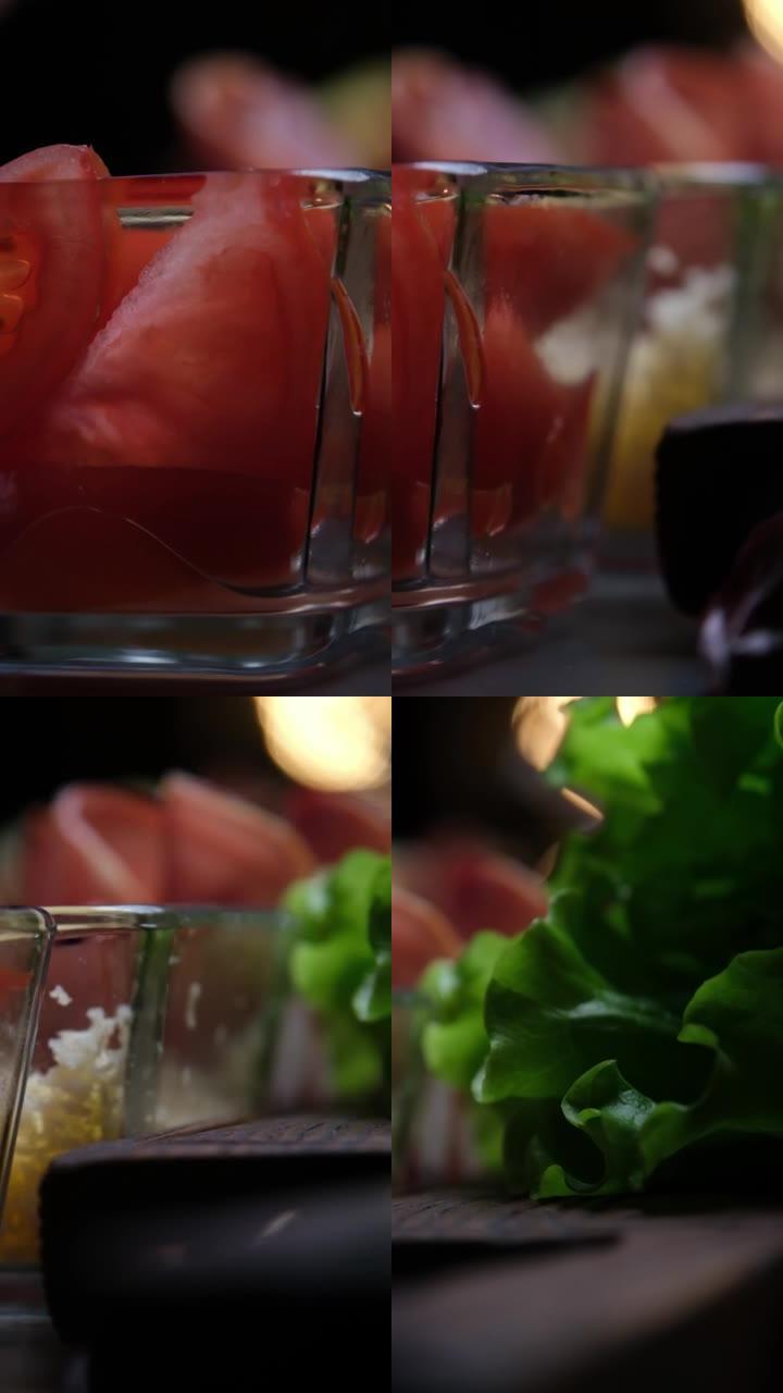 玻璃碗中的新鲜番茄楔入，桌上的生菜