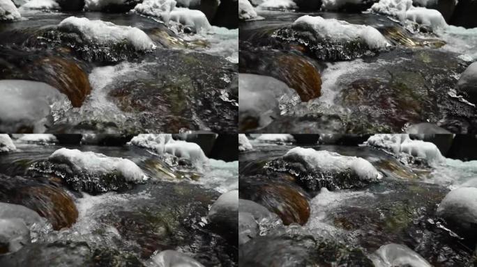 在针叶林中流淌的山区河流的死水特写。冰雪中的冰冻石头。横向移动滑动。广角