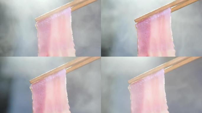 在用筷子搅拌的煮汤火锅中蘸切成薄片的优质猪肉的ECU慢动作镜头