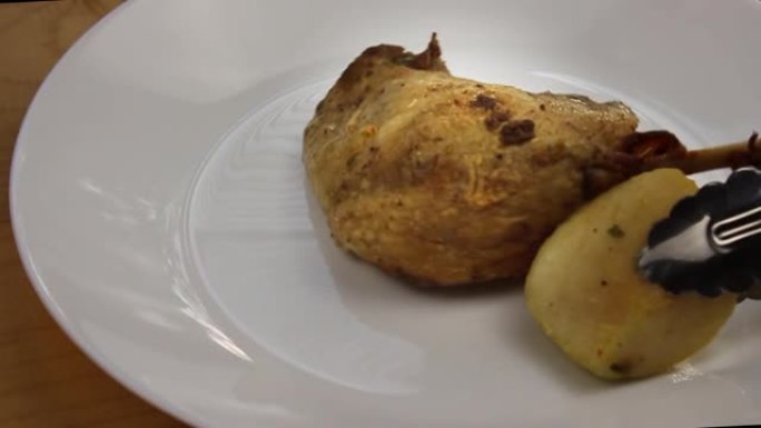 新鲜美味的苹果烤鸭。土豆肉。厨师把鸭肉放在盘子里。烤苹果。