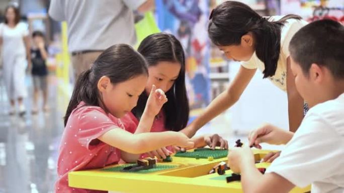 亚洲儿童在百货商店玩具中心一起玩玩具积木，生活方式概念。