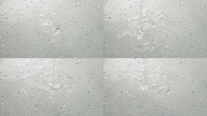 一小撮带有微小气泡的透明化妆品凝胶滴落在表面上。面部精华液，抗衰老霜，洗发水，抗菌凝胶，透明质酸