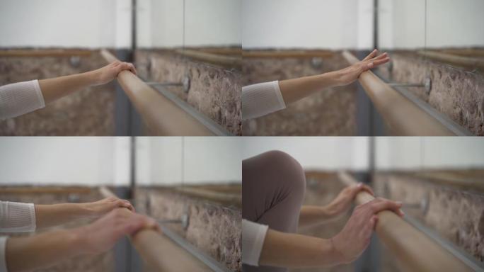 在舞蹈室，一只手握着一只手的特写镜头。