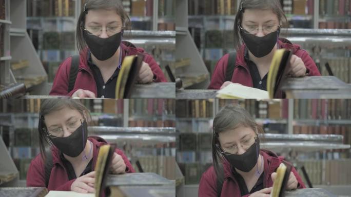 戴着眼镜和面具对抗病毒的白人妇女在图书馆看书