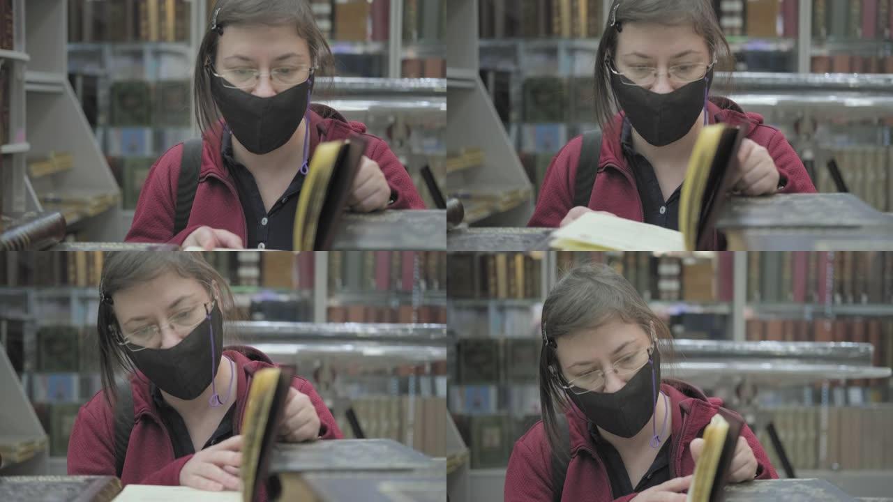 戴着眼镜和面具对抗病毒的白人妇女在图书馆看书
