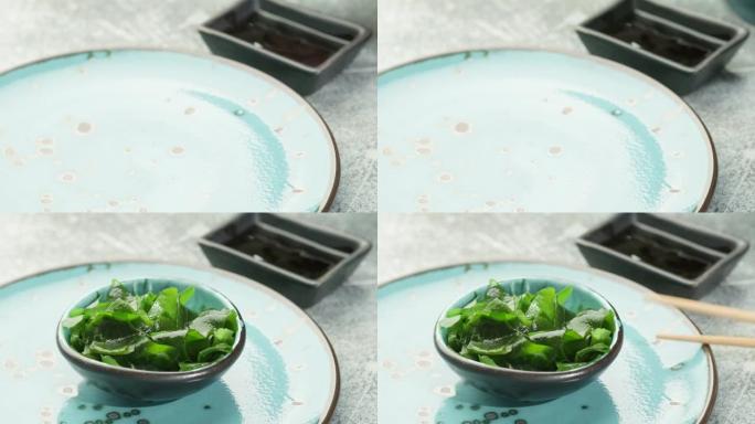 女人摆桌子吃午饭。泡在碗里的裙带菜海藻。日本料理。健康海鲜。
