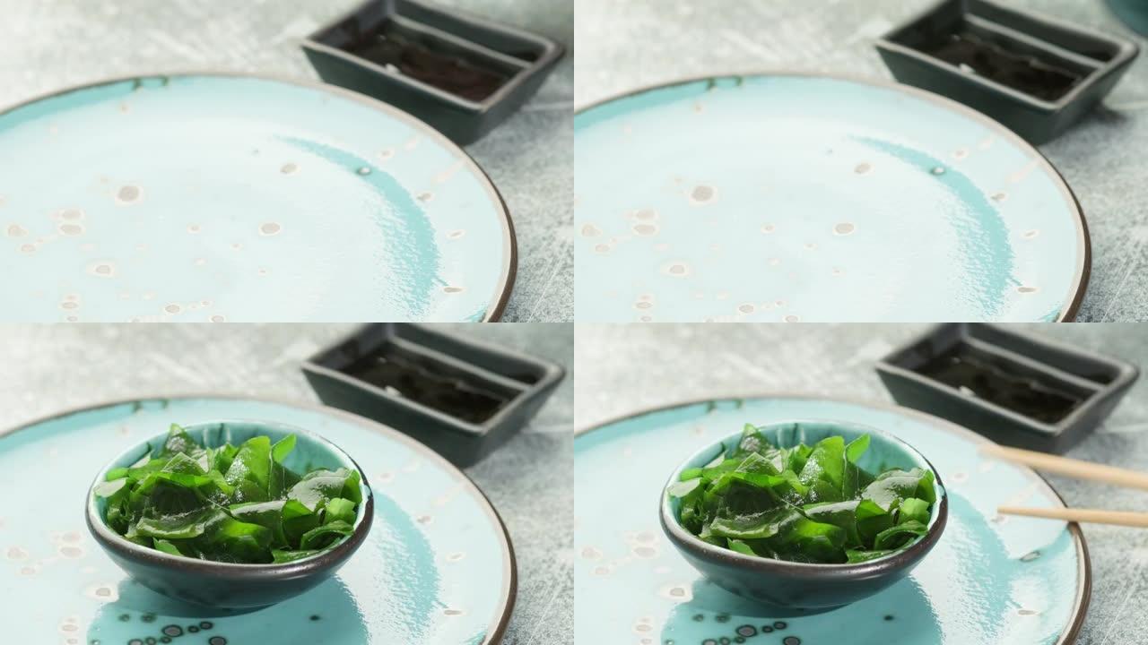 女人摆桌子吃午饭。泡在碗里的裙带菜海藻。日本料理。健康海鲜。
