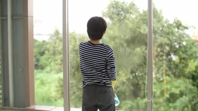 男孩用海绵洗窗户玻璃，父子一起打扫房子