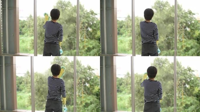 男孩用海绵洗窗户玻璃，父子一起打扫房子