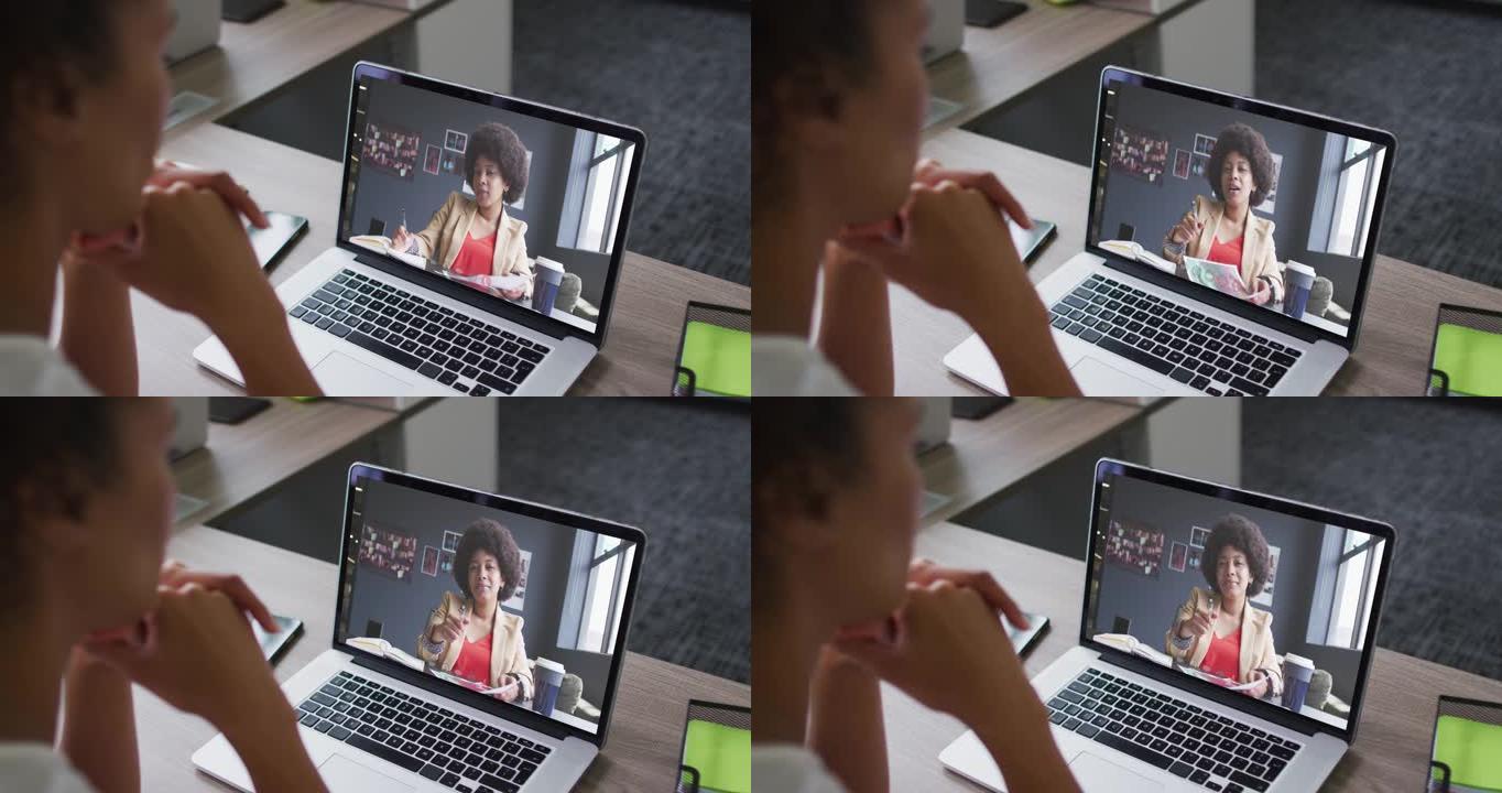 非裔美国妇女的中部与办公室的女同事在笔记本电脑上进行视频通话