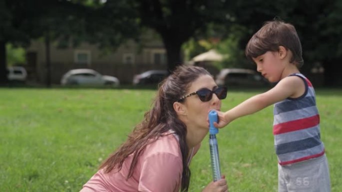 夏天，母亲和她的小儿子在公园里吹泡泡
