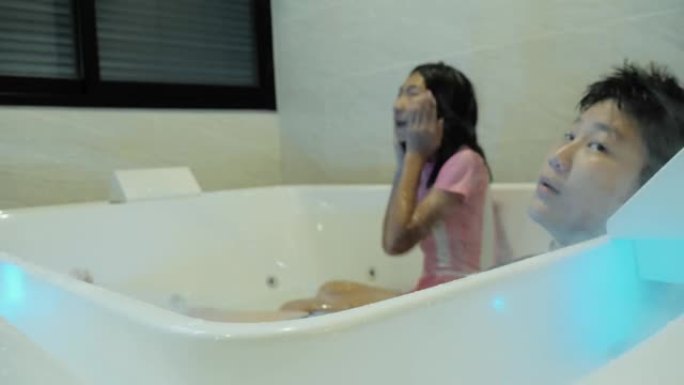 快乐的亚洲儿童在度假期间在酒店房间里一起在热水浴缸里有新的体验，生活方式理念。