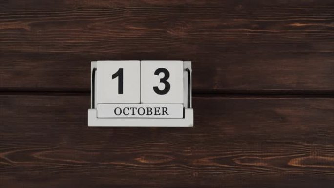 10月日历，更改天数。手工制作的木日历，日期和日放在木桌上。这个月的时间节奏很快。加速日历。时间过得