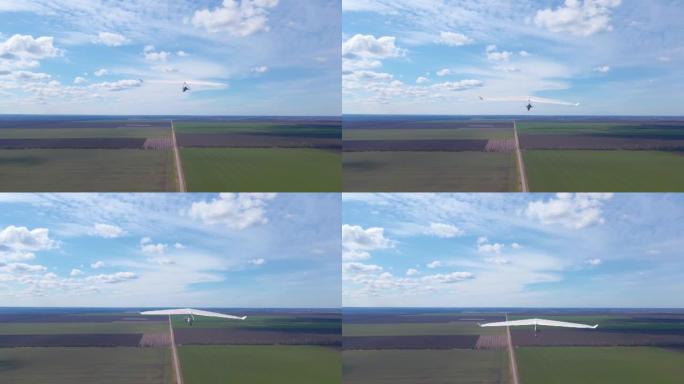 悬挂式滑翔机机翼在阳光明媚的绿色田野上方飙升