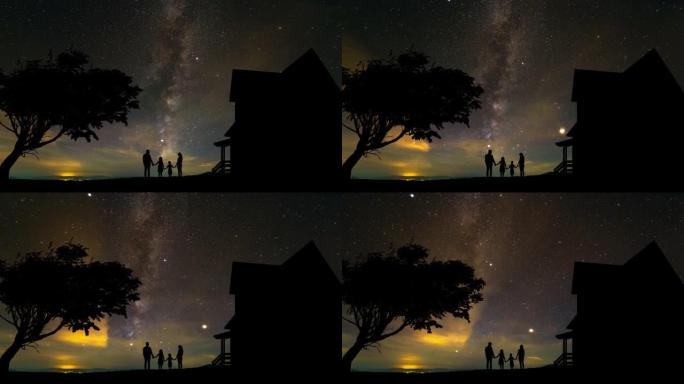 一家人站在星空背景上的房子附近