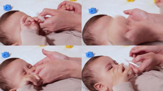 母亲用滴鼻剂给婴儿。婴儿鼻腔滴注。男婴因生病和鼻涕而哭泣