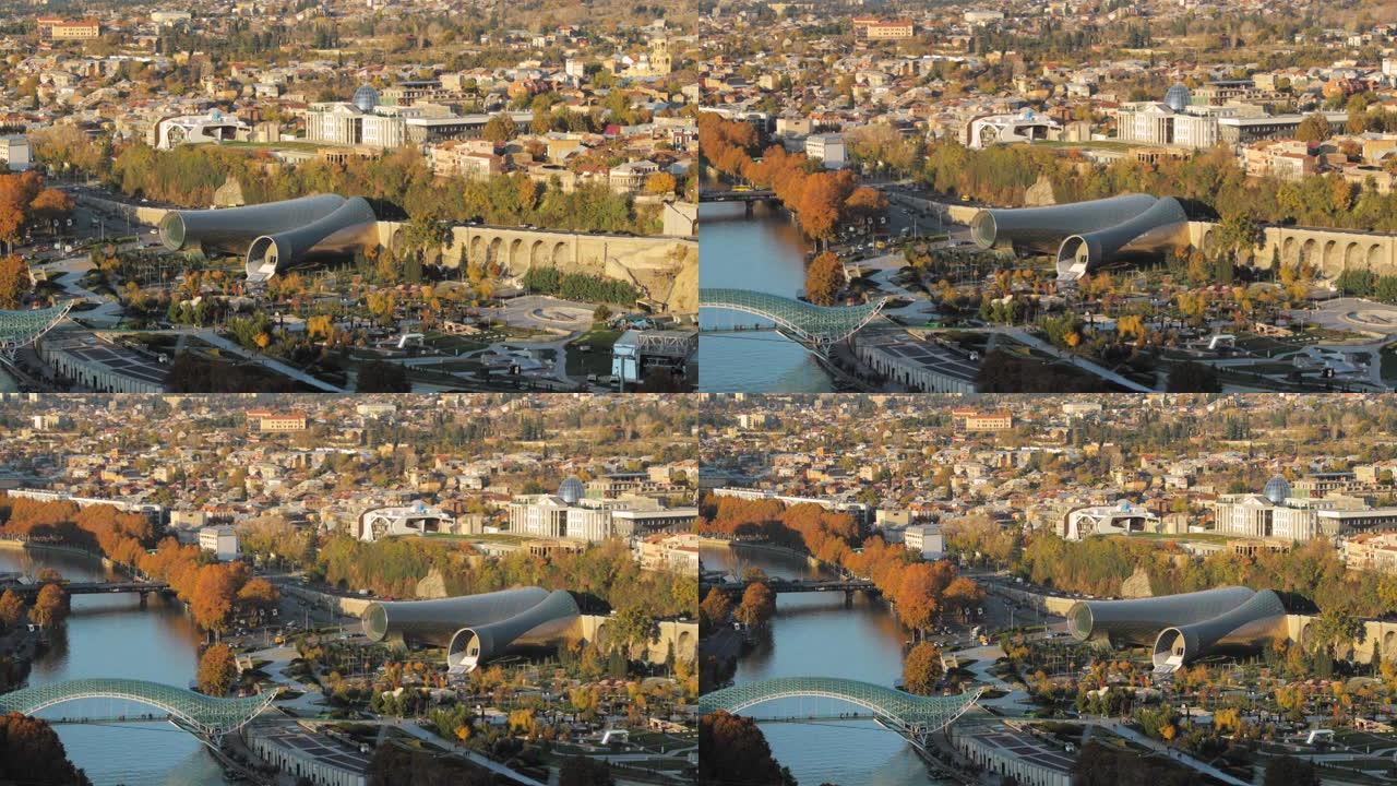 格鲁吉亚第比利斯。秋季傍晚著名地标的俯视图。格鲁吉亚首都天际线城市景观。和平之桥、音乐厅、日克公园和