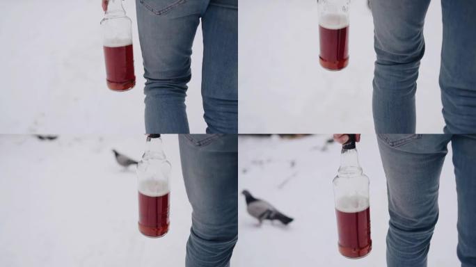 一个人走过雪地，手里拿着一瓶酒精。运动中的特写拍摄
