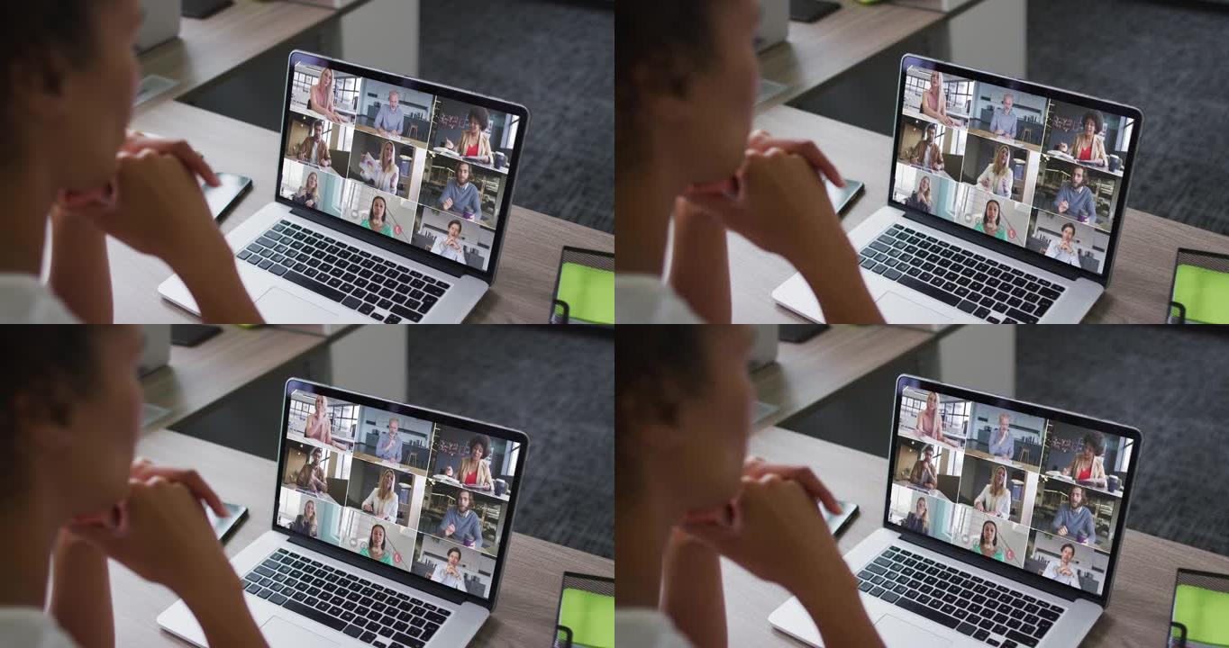 非裔美国妇女的中部与办公室的同事在笔记本电脑上进行视频会议