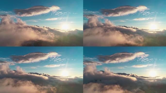 无人机摄像机在日落时穿越中亚雪山上方的云层拍摄。
