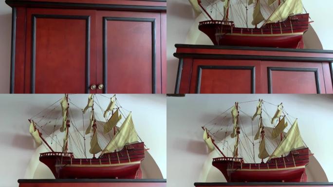 一个带有古董船模的木制旧衣柜，上面放着旧快船