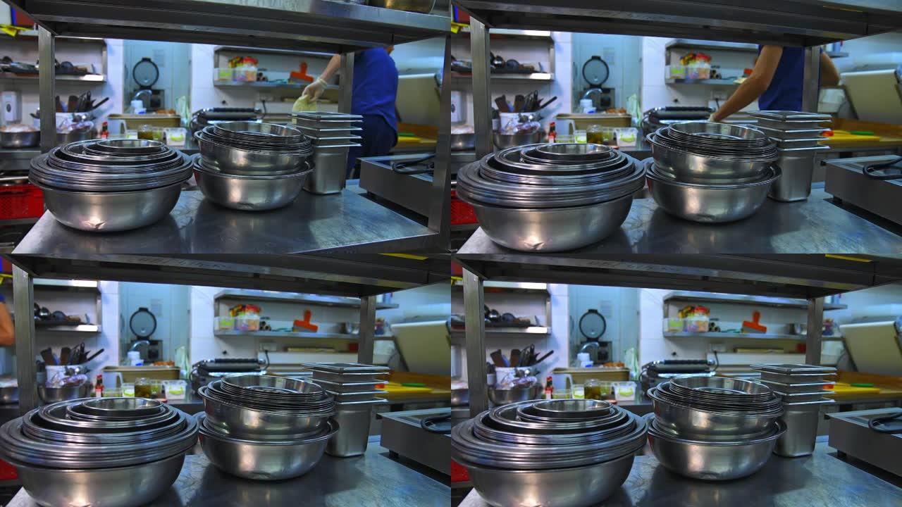 烹饪用不锈钢碗。厨房用具。厨房架子上的许多碗。