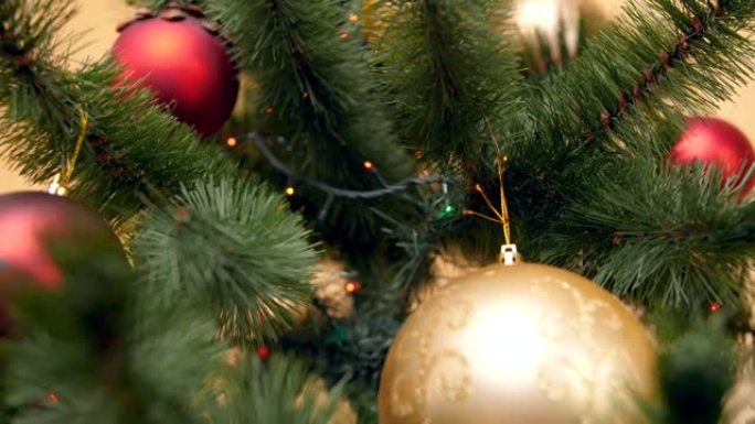 相机的特写4k平移视频缓慢地沿着装饰有小玩意，灯光和花环的圣诞树向下移动。为您的寒假和庆祝活动完美拍