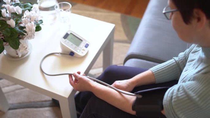 高级妇女在家中测量血压