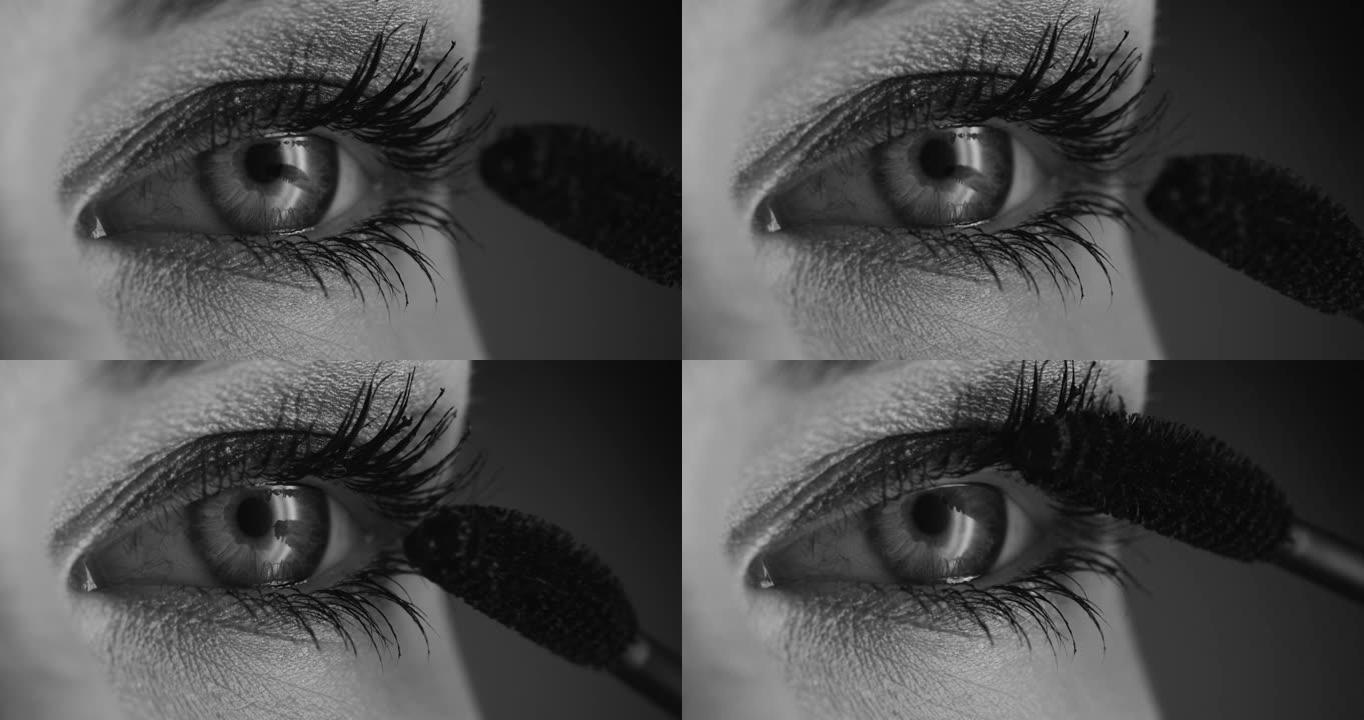 化妆申请的步骤。将睫毛膏涂在女性眼睛上的特写镜头。黑白视频。