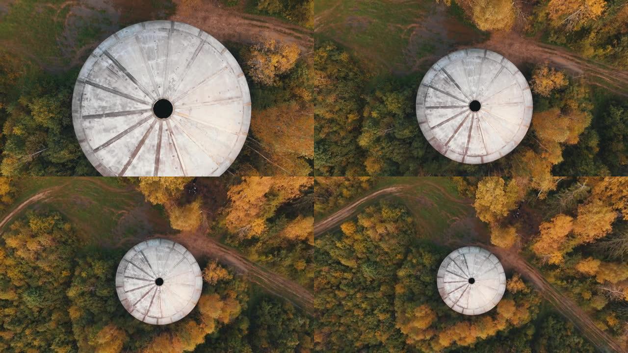 大型白色球体，顶部有孔，位于茂密的森林中