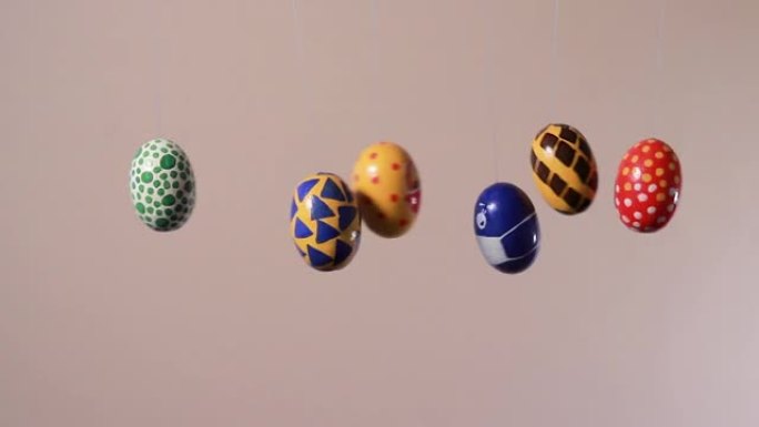 五颜六色的复活节彩蛋在脸上的面具中推动冠状病毒的彩蛋。复活节假期期间的covid大流行概念在医学和世