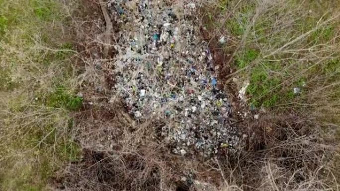 森林里的垃圾场。生态问题。春季森林中部的非法垃圾场。空中俯视图。一堆塑料袋，食物垃圾，垃圾，扔在户外