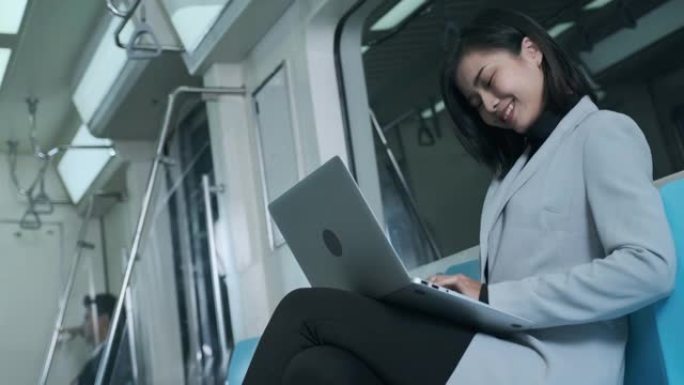 女商人半夜在电动火车上用笔记本电脑讨论工作。
