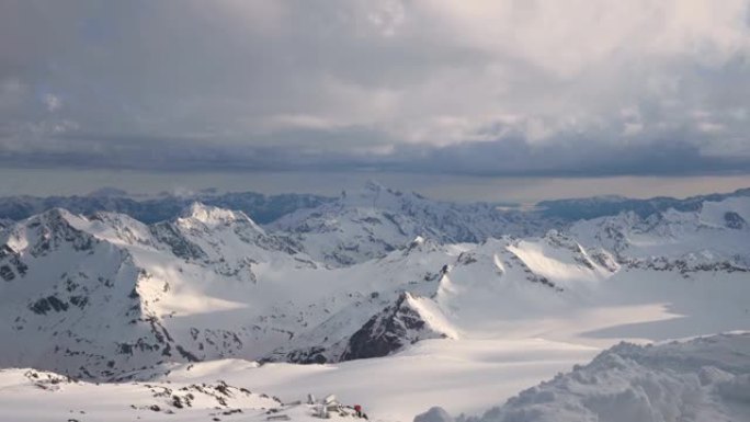 从4000米高高的雪山岩石的高度延迟，冰川和高加索主岭的山脉，傍晚的日落橙色云和山顶上的冰川。