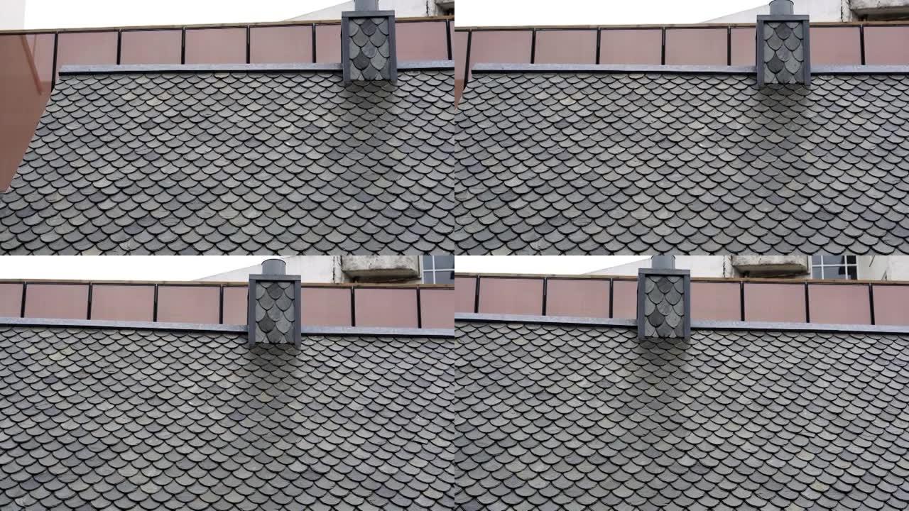 欧洲房屋屋顶和烟囱上方的灰色瓷砖鱼鳞瓷砖屋顶
