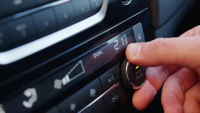 在车内设置空调。手转动空调环。显示屏指示车内温度。车内的冷却空气