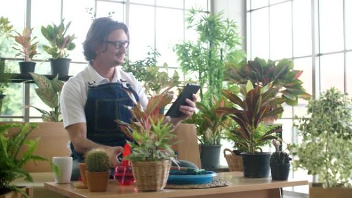 快乐的高级男子在花店为顾客捕捉小植物的照片