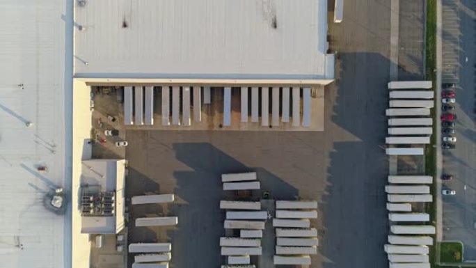 空中鸟瞰正上方的一个仓库有一个卡车停车场。带有平移相机运动的无人机制作的镜头。