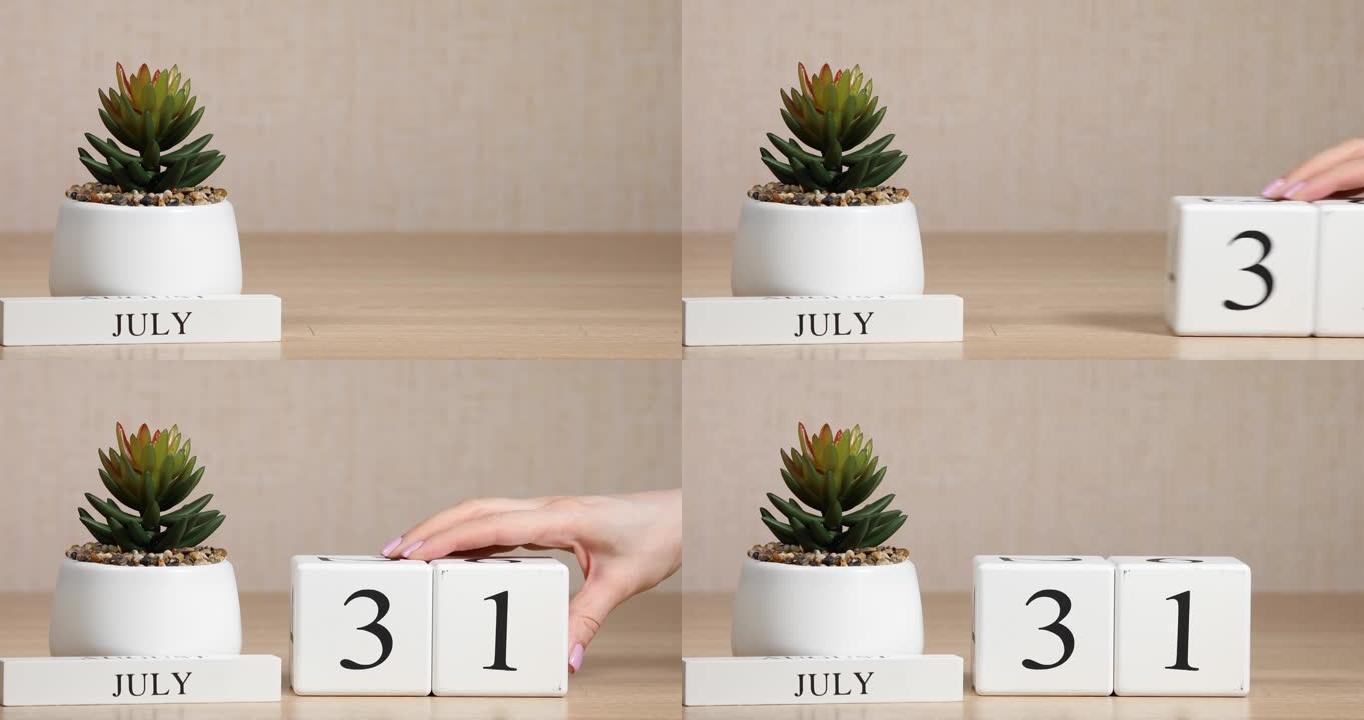 木制日历对7月31日来说是一个重要的事件，女人的手在日历上设置日期。夏季。