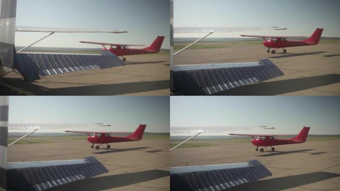 运动型红色双座飞机。机场，阳光，早晨。大自然，出了门，铺好的路。飞机正准备飞行。特写