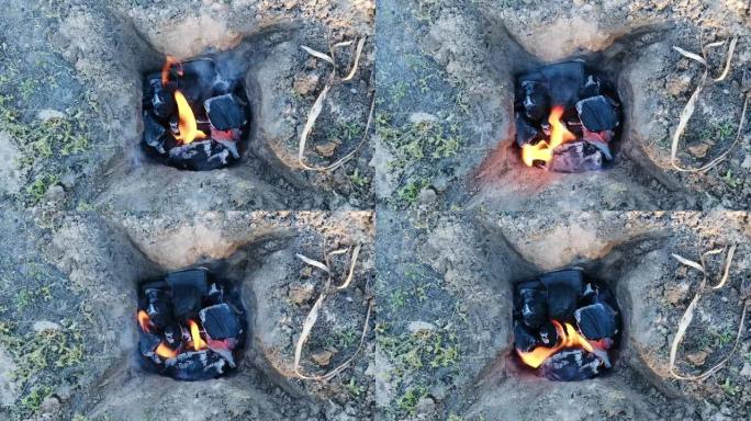 烧烤煤在地上燃烧。准备徒步旅行时的食物。