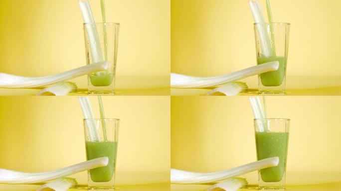 将美味的有机芹菜汁倒入黄色背景上的玻璃中