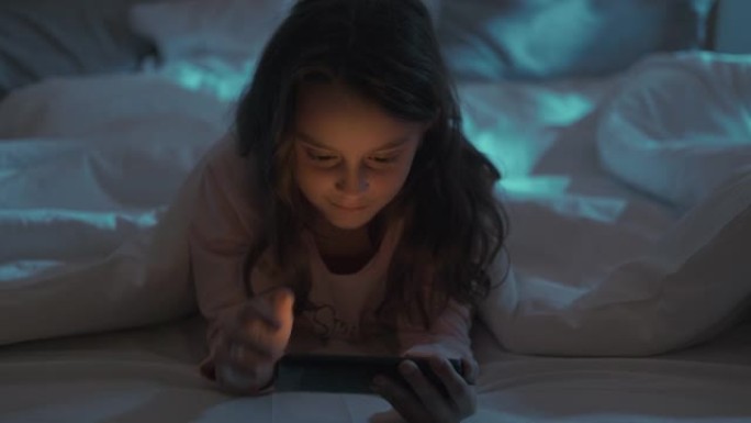 夜间电影儿童床休闲女孩看手机