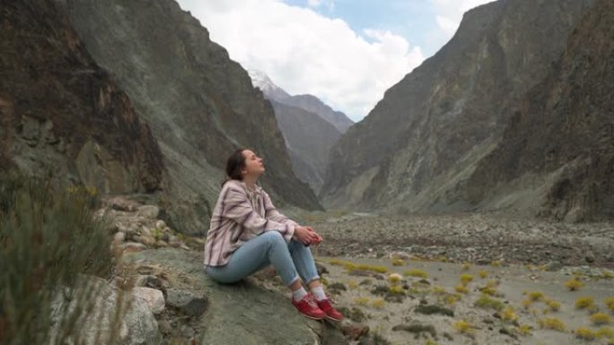 巴基斯坦北部山区背景上的黄色花朵妇女肖像